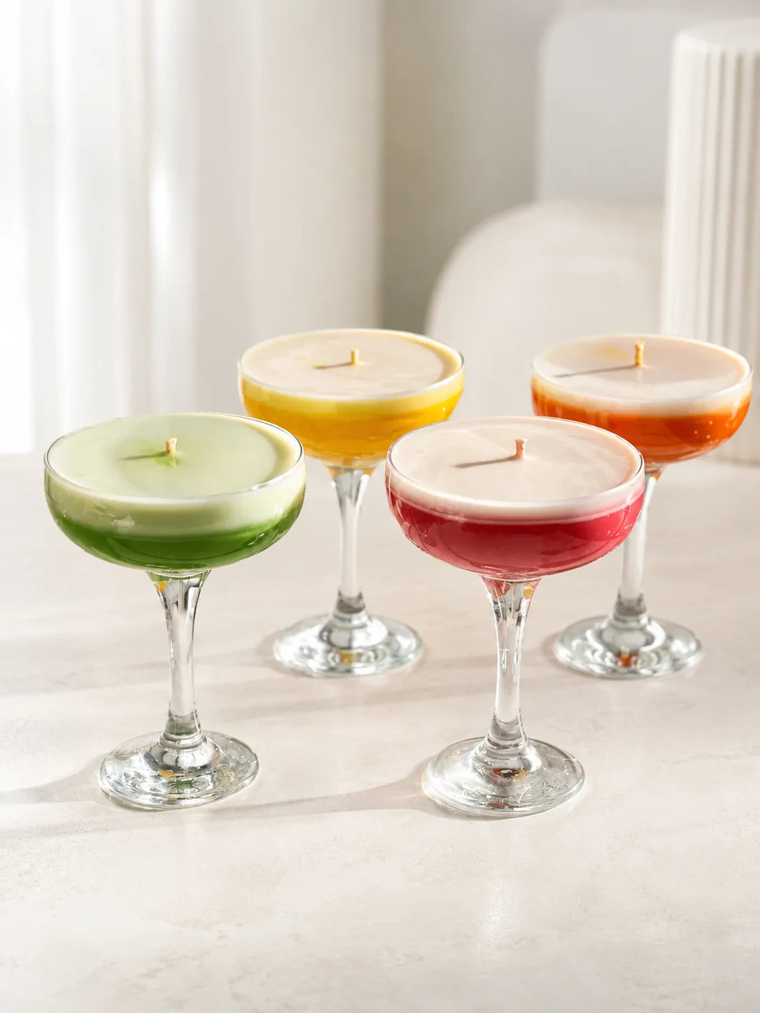 Colorful container candles in cocktail glasses